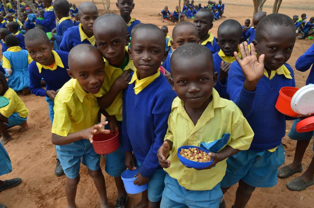 Estudiantes disfrutan una comida saludable el la escuela primara King’utheni en la área afectada por la sequía en Kibwezi, al sur de Kenia, donde misioneros Maryknoll patrocinan varios proyectos.(Moses Njagua Gitahi/Kenya)