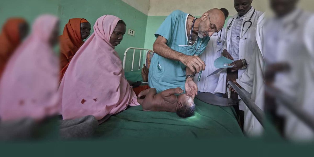 El Dr. Tom Catena, un misionero laico católico de Estados Unidos, examina a un bebé durante su ronda, a finales de abril, en el Hospital Madre de la Misericordia de Gidel, una localidad situada en las montañas de Nuba, en Sudán. Este hospital católico, en el que Catena suele ser el único médico, es el único centro de referencia en esta zona devastada por la guerra. (CNS/Paul Jeffrey/Sudán)