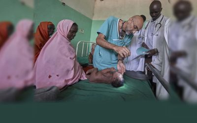El Dr. Tom Catena, un misionero laico católico de Estados Unidos, examina a un bebé durante su ronda, a finales de abril, en el Hospital Madre de la Misericordia de Gidel, una localidad situada en las montañas de Nuba, en Sudán. Este hospital católico, en el que Catena suele ser el único médico, es el único centro de referencia en esta zona devastada por la guerra. (CNS/Paul Jeffrey/Sudán)