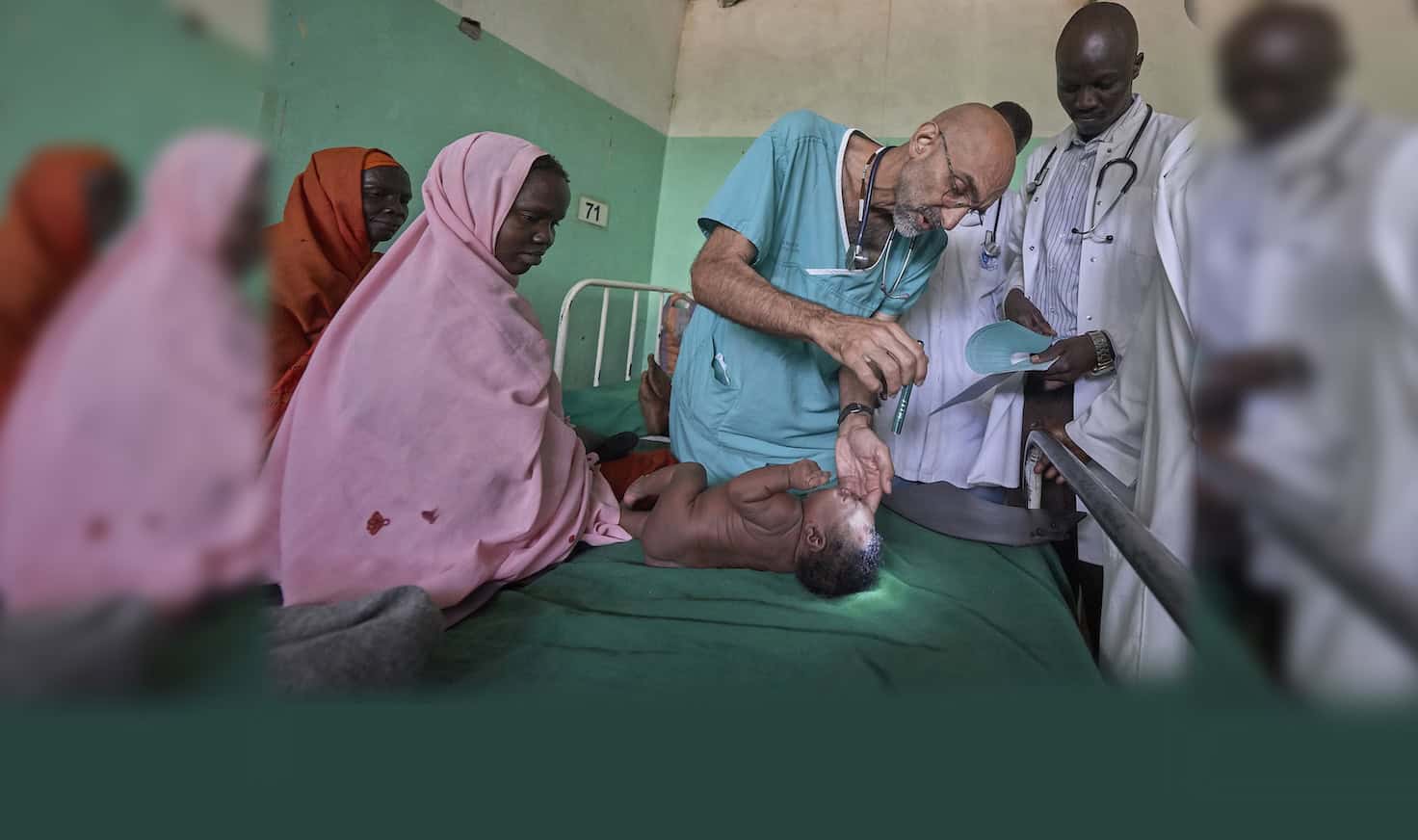 El Dr. Tom Catena, un misionero laico católico de Estados Unidos, examina a un bebé durante su ronda, a finales de abril, en el Hospital Madre de la Misericordia de Gidel, una localidad situada en las montañas de Nuba, en Sudán. Este hospital católico, en el que Catena suele ser el único médico, es el único centro de referencia en esta zona devastada por la guerra. (CNS/Paul Jeffrey/Sudán)