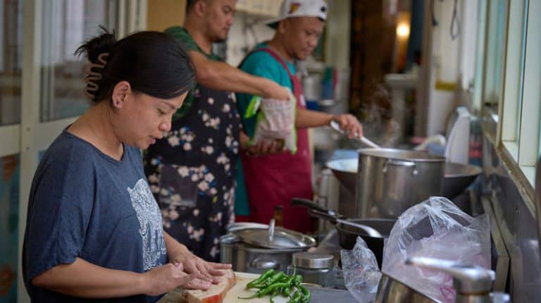 Cindy Sevilla y otros residentes preparan la comida en el albergue de acogida Ugnayan, en Taichung (Taiwán). El albergue acoge a trabajadores migrantes que se han visto obligados a abandonar sus puestos de trabajo debido a malos tratos, a despidos inesperados o a otros problemas legales, laborales o de salud. (Paul Jeffrey/Taiwán)