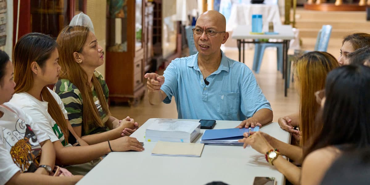 El Padre Joyalito Tajonera se reúne con un grupo de trabajadores de fábrica en el albergue de Ugnayan. El misionero asesora a trabajadores migrantes sobre sus derechos y responsabilidades como extranjeros en Taiwán. (Paul Jeffrey/Taiwán)