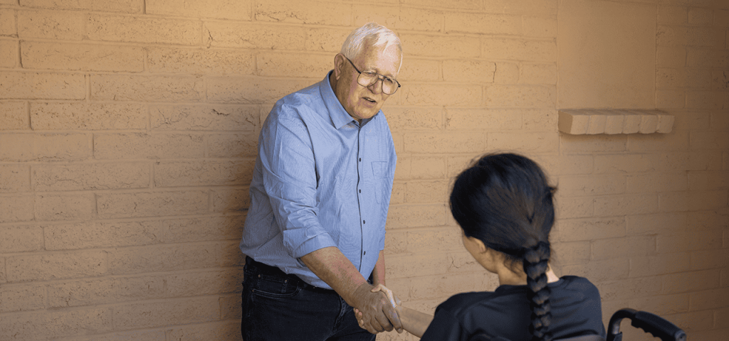 Rubén García, director de la red de albergues Annunciation House con historial de más de 48 años en El Paso, Texas, le da la bienvenida a una joven inmigrante con discapacidad. (Octavio Durán/EE. UU.)
