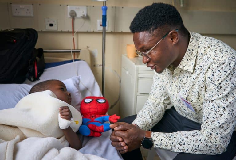 El candidato Alois Simpilisi visita a un niño en el hospital St. Francis Community en Nairobi, Kenia, donde es capellán como parte de su ministerio pastoral y de discernimiento. (Paul Jeffrey/Tanzania)