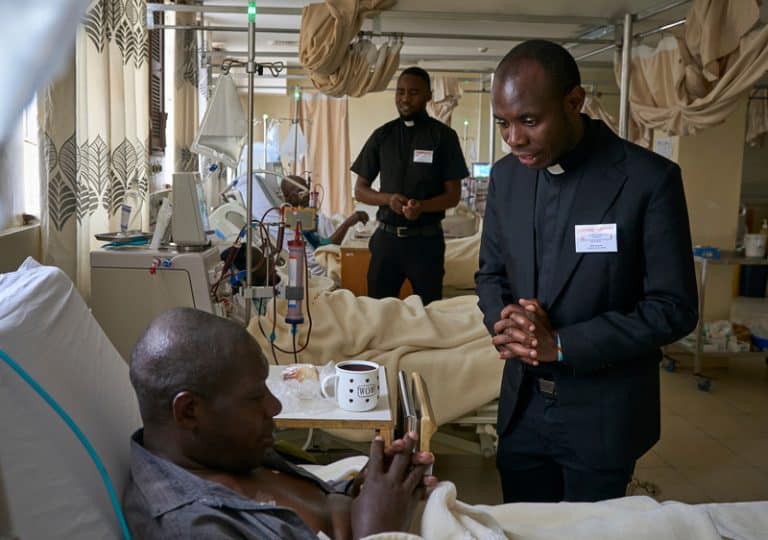 Para su experiencia pastoral, los candidatos Frederick Richard Luhende (izq.) y Babluu Ekama Kyamba (dcha.) visitan a pacientes en el hospital St. Francis Community en Nairobi, Kenia. (Paul Jeffrey/Tanzania))
