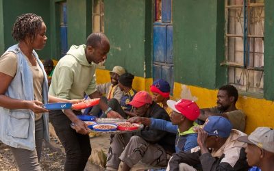 Como parte de su discernimiento al sacerdocio, Babluu Ekama Kyamba sirve comida a familias sin hogar en el barrio de Mathare en Nairobi, Kenia, junto a la voluntaria Elizabeth Omollo. (Paul Jeffrey/Tanzania)