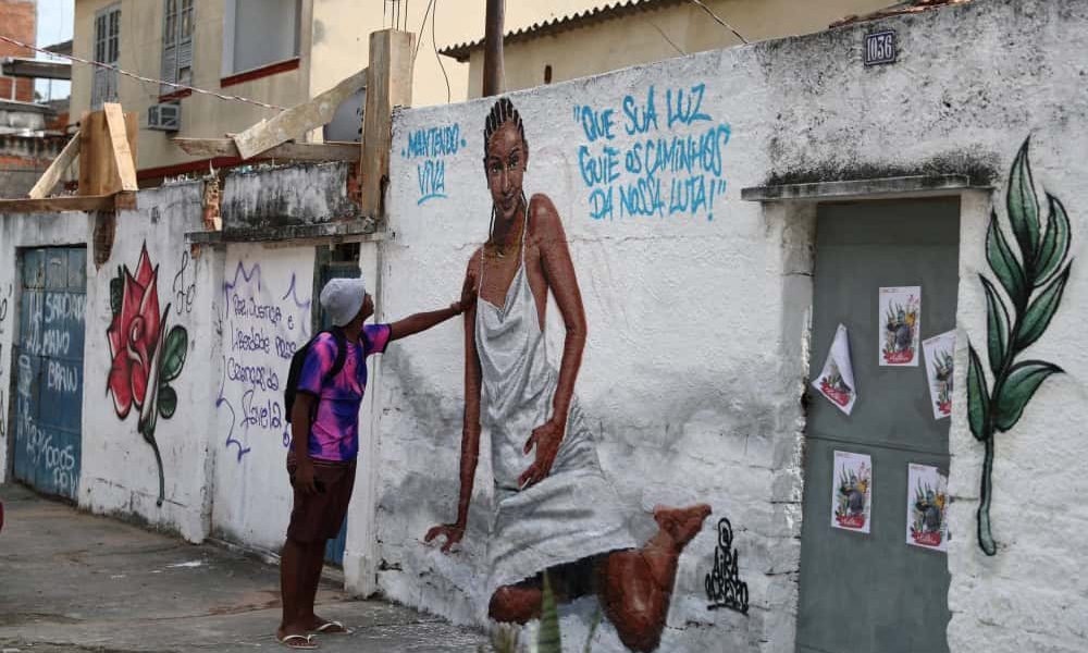 Un hombre observa una obra de arte creada por artistas en homenaje a Kathlen Romeu en un barrio pobre de Río de Janeiro, el 14 de junio de 2021. La diseñadora de interiores, de 24 años, estaba embarazada cuando fue asesinada a tiros el 8 de junio durante una operación policial, según los medios locales. El grafiti dice: “Que tu luz guíe los caminos de nuestra lucha”. (CNS/Pilar Olivares, Reuters)