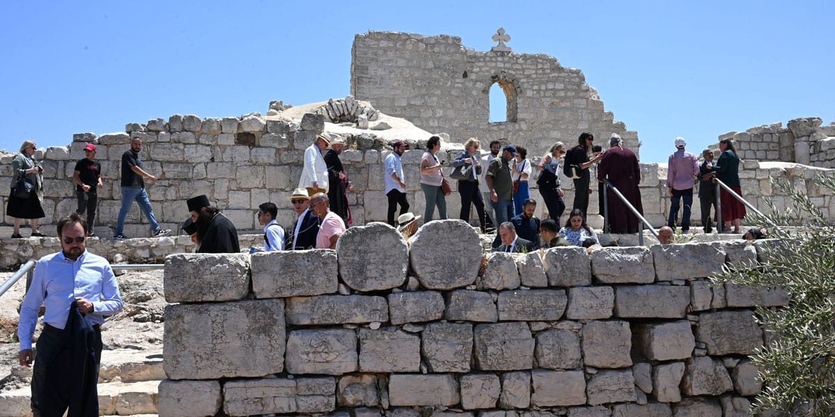Diplomáticos, sacerdotes y periodistas visitan la iglesia de San Jorge, del siglo V, durante una visita de solidaridad con los patriarcas y los líderes de las iglesias de Jerusalén a la localidad cristiana palestina de Taybeh, en Cisjordania, el 14 de julio de 2025. La visita se llevó a cabo como respuesta al ataque del 7 de julio, en el que colonos israelíes radicales provocaron un incendio cerca del cementerio del pueblo y de la iglesia. (OSV News/Debbie Hill)