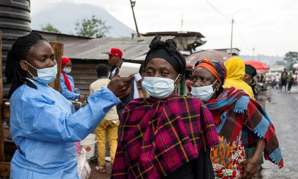 Una trabajadora de la salud toma la temperatura a una mujer que pasa por el puesto de control de Kanyaruchinya para ingresar a la ciudad de Goma, en el Congo, el 20 de mayo de 2026, mientras las autoridades y las agencias de ayuda intensifican sus esfuerzos para contener un nuevo brote de ébola causado por la cepa Bundibugyo. (OSV News/Arlette Bashizi, Reuters)