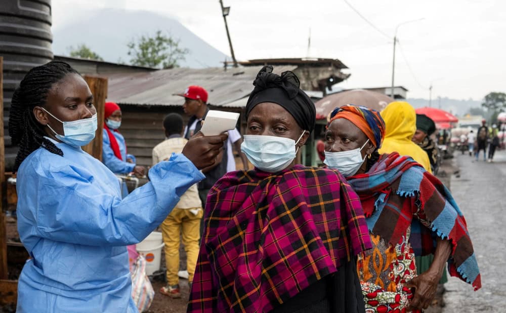 Una trabajadora de la salud toma la temperatura a una mujer que pasa por el puesto de control de Kanyaruchinya para ingresar a la ciudad de Goma, en el Congo, el 20 de mayo de 2026, mientras las autoridades y las agencias de ayuda intensifican sus esfuerzos para contener un nuevo brote de ébola causado por la cepa Bundibugyo. (OSV News/Arlette Bashizi, Reuters)