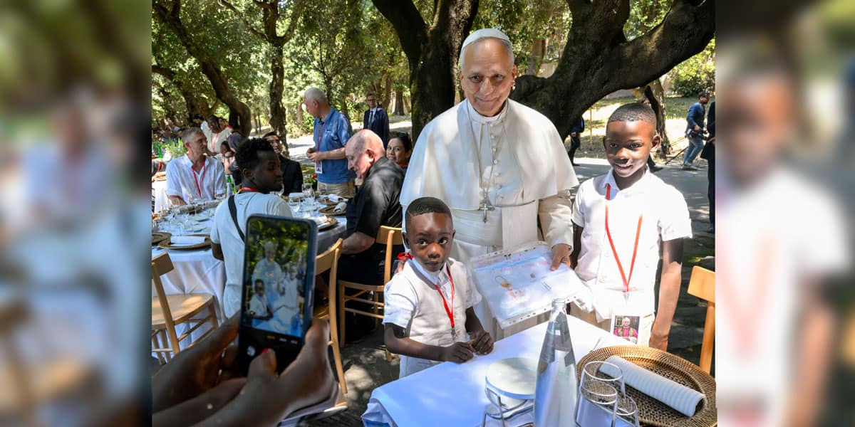 el Papa León XIV posa para una fotografía con dos niños durante un almuerzo con personas vulnerables de la diócesis de Roma en Borgo Laudato Si, en los jardines pontificios de Castel Gandolfo, Italia, el 11 de julio de 2026. (OSV News/Simone Risoluti, Vatican Media)