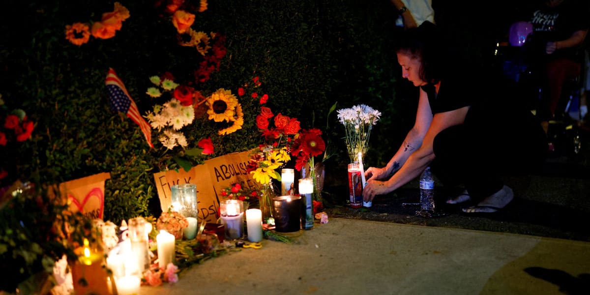 Una mujer coloca una vela en un memorial improvisado en Mechanics Park, en Biddeford, Maine, el 13 de julio de 2026, después de que un agente del Servicio de Inmigración y Control de Aduanas de EE.UU. (ICE) matara a tiros a un conductor. (OSV News/CJ Gunther, Reuters)