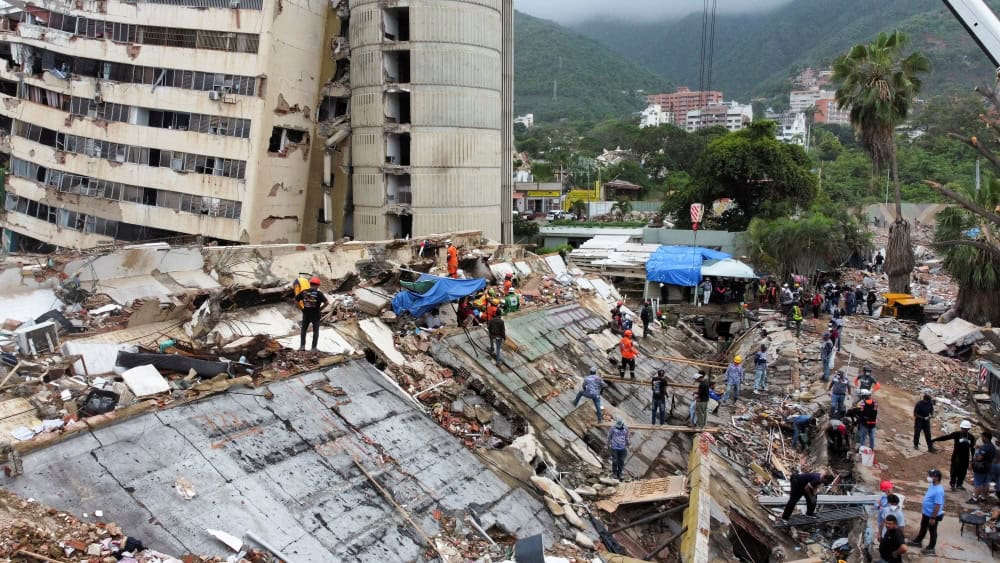 Una imagen tomada desde un dron muestra a los equipos de rescate y a los voluntarios en Los Cocos, La Guaira, Venezuela, el 11 de julio de 2026, buscando entre los escombros tras los sismos del 24 de junio. Dos sismos catastróficos azotaron a Venezuela en rápida sucesión el 24 de junio, dejando más de 6.000 muertos. (OSV News/Leonardo Fernández Viloria, pool vía Reuters)