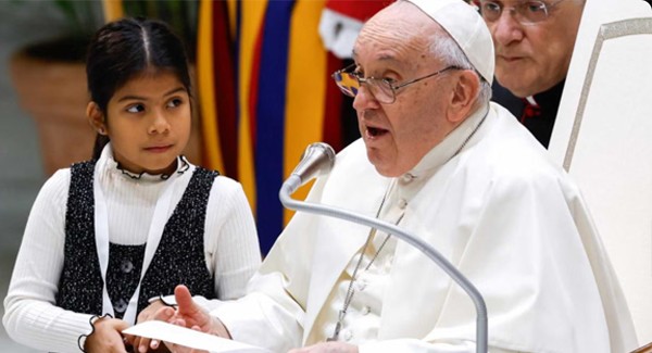 A girl listening to Pope Francis answer questions at the Vatican