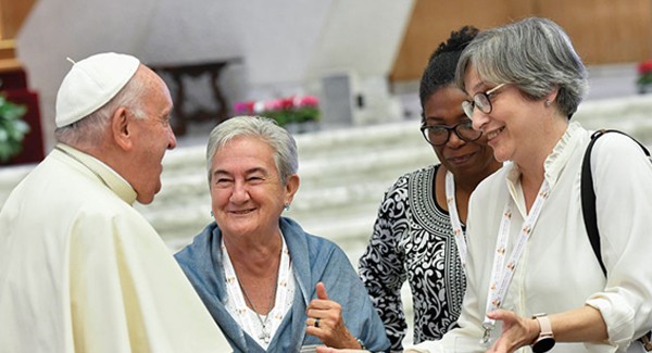 Pope Francis shares a laugh with some of the women members of the assembly of the Synod of Bishops