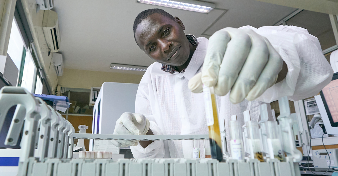 A man dressed in laboratory gear works in a clinic.