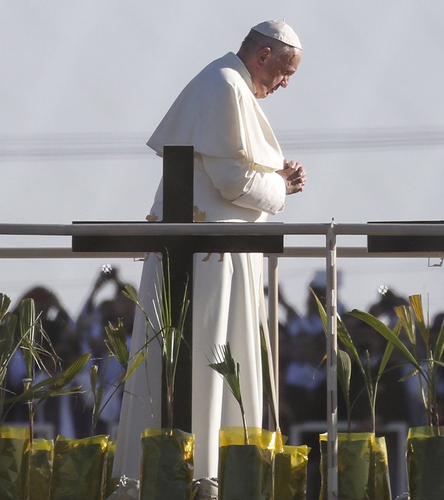 Pope Francis prays overlooking the U.S.-Mexico border before celebrating Mass in Ciudad Juarez, Mexico, Feb. 17. About 550 guests situated on a levee north of the Rio Grande in Texas took part in the Mass.