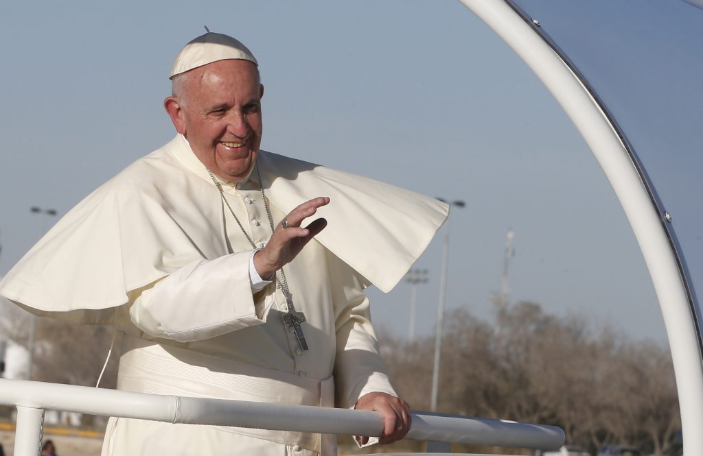 Pope Francis waves from the Popemobile after praying at a cross on the border with El Paso, Texas, in Ciudad Juarez, Mexico.