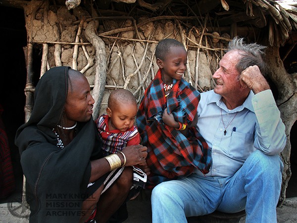 Fr. Dan in a refugee camp in Tanzania talking with a father and his two sons