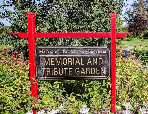 Maryknoll Fathers and Brothers Memorial and Tribute Garden sign with the garden in the background.