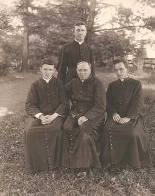 Leaving for Maryknoll's new mission field in South China are Fathers Francis X. Ford (seated, right), Bernard Meyer (standing), co-founder Thomas F. Price (seated, center) and James E. Walsh (seated, left).