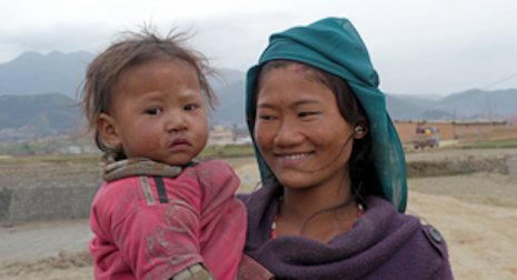 A smiling mother holds a baby