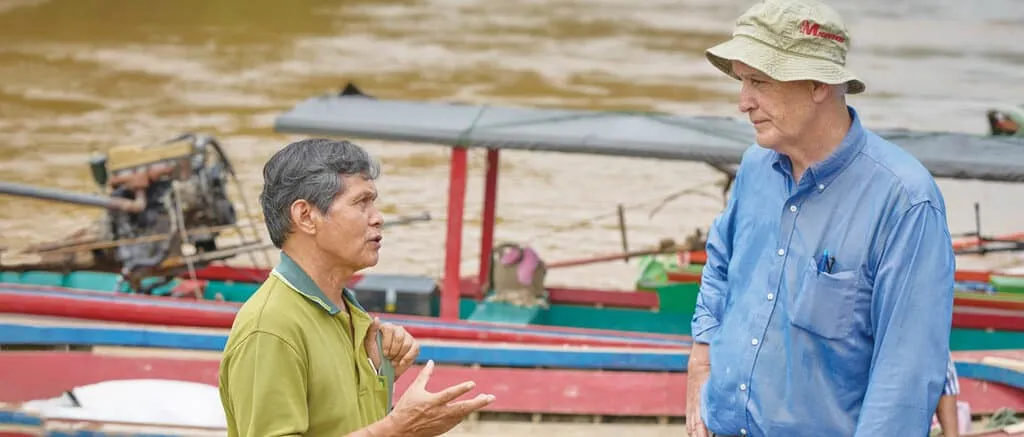 Maryknoll Father John Barth speaking with a local Catholic catechist, Kler, along the Salween River in Myanmar