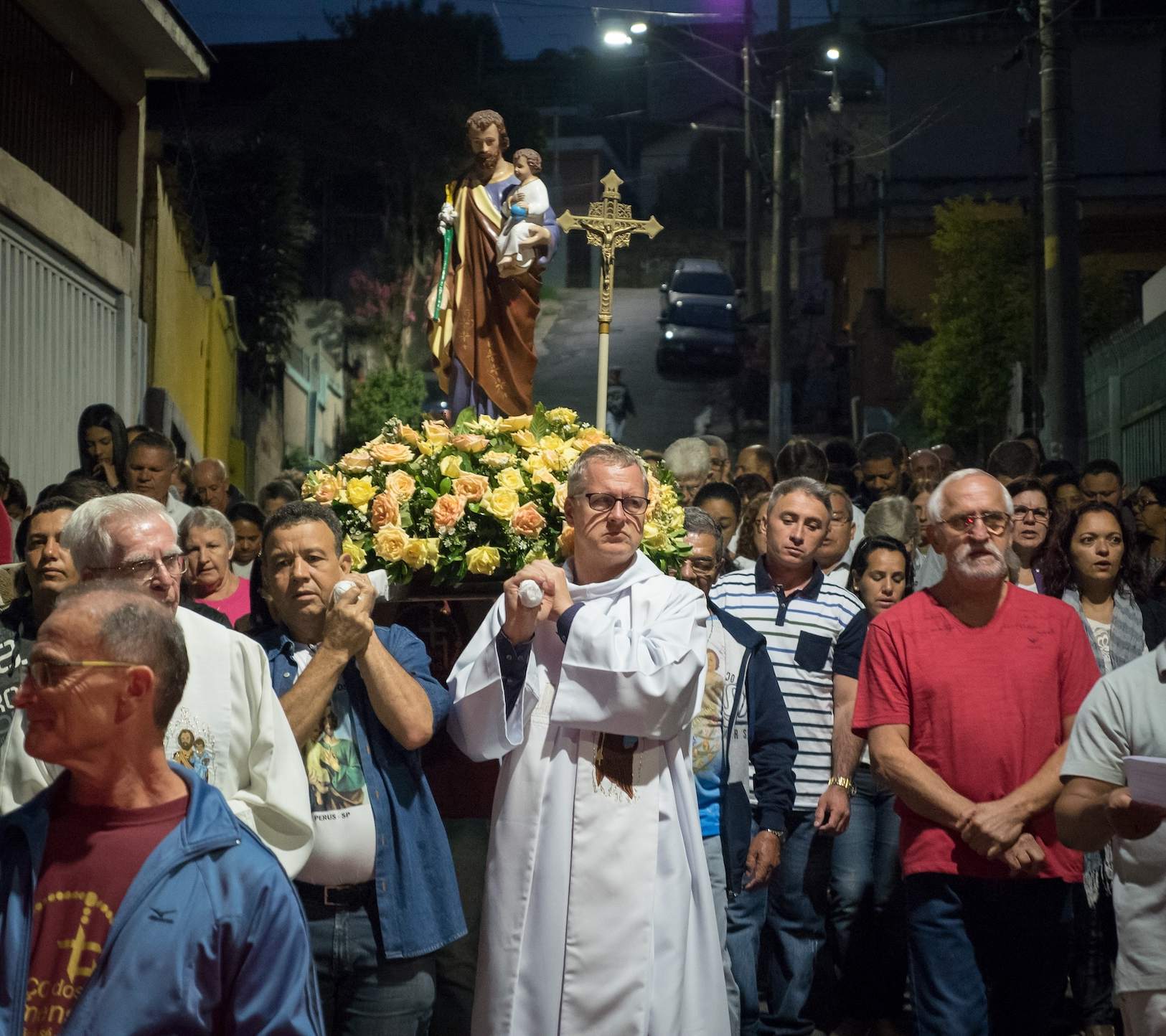 Fr. Dennis Moorman, M.M. leads a procession of people in the street.