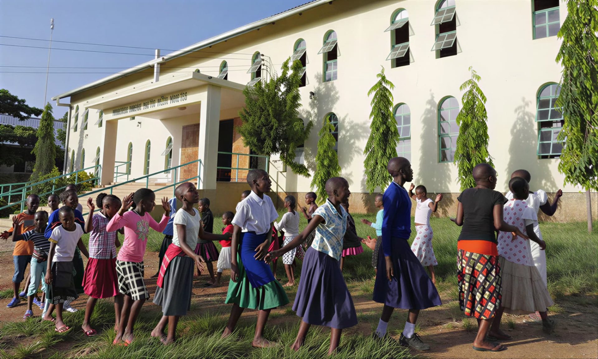 A group of girls are walking in front of the Transfiguration Parish in Mabatini, Mwanza